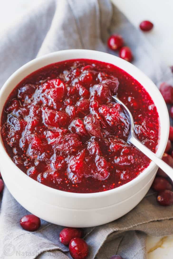 A bowl of homemade cranberry sauce with a spoon.