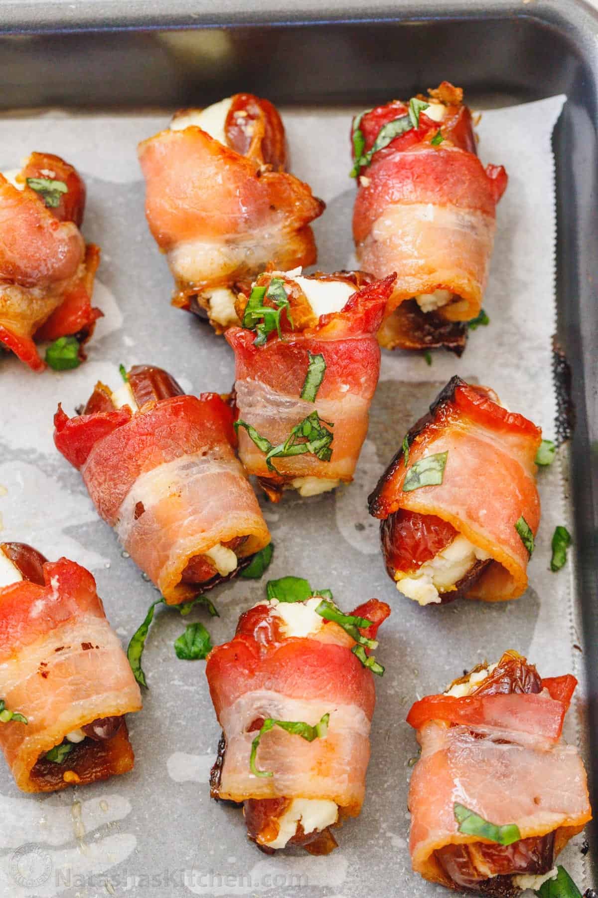 Stuffed Dates are an irresistible appetizer stuffed with goat cheese and wrapped in crispy bacon. This stuffed dates recipe is always a hit at parties. Made ahead stuffed dates on baking sheet