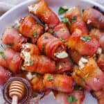 Bacon wrapped stuffed dates on a serving platter