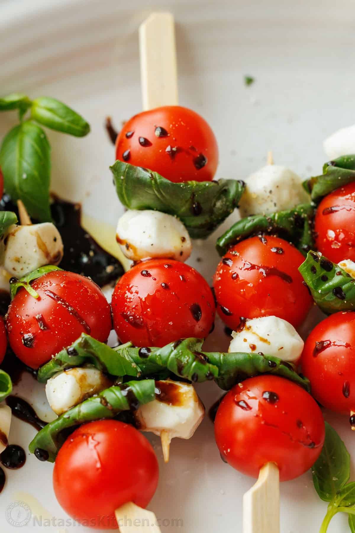 Caprese Skewers is the bite-sized version of the classic Caprese Salad. It takes 10 minutes and 4 ingredients to make these fancy appetizers! Tomato mozzarella appetizers with balsamic glaze dipped over top