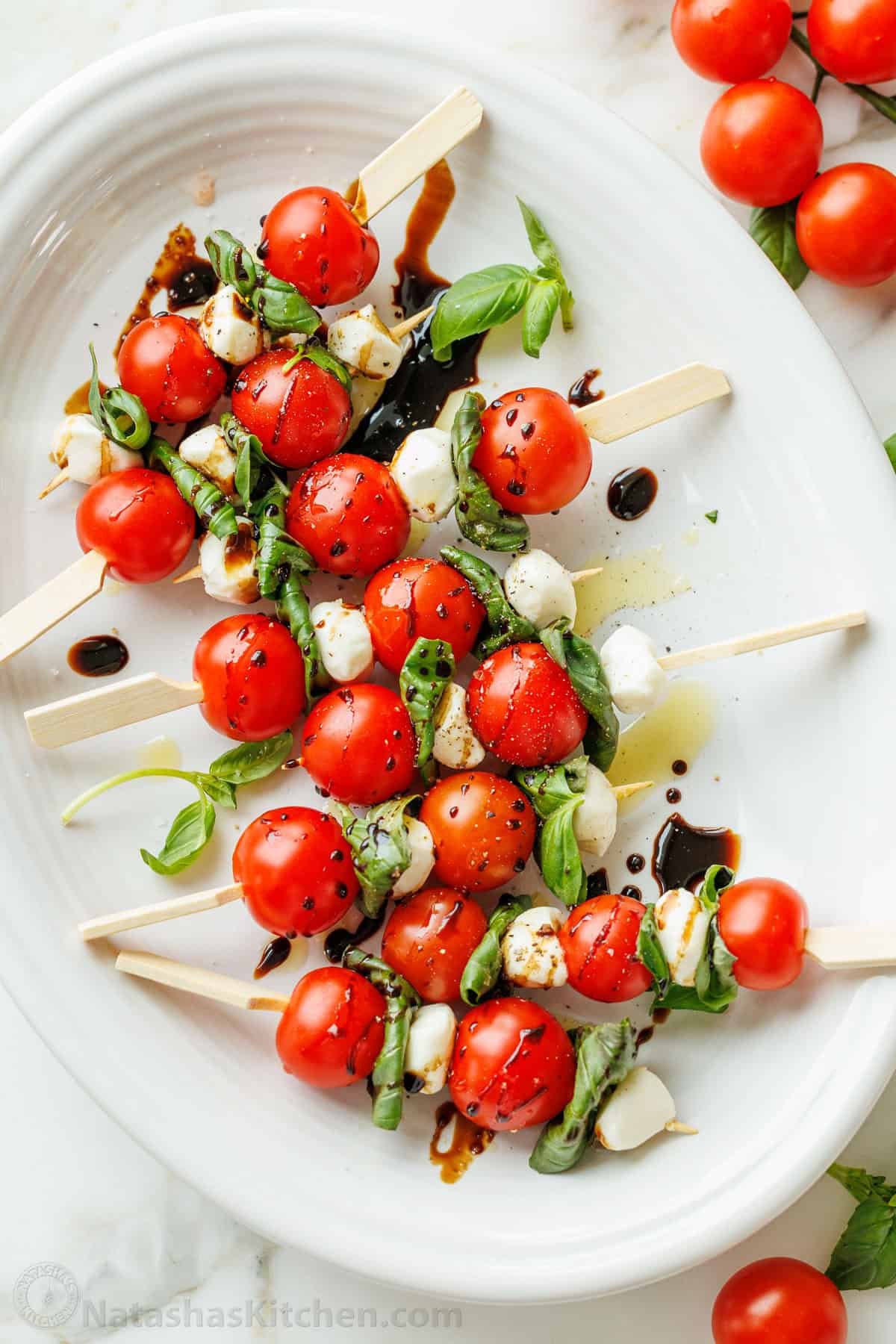 Caprese Skewers is the bite-sized version of the classic Caprese Salad. It takes 10 minutes and 4 ingredients to make these fancy appetizers! Balsamic glaze dripped over Italian tomato and mozzarella appetizers served on a platter