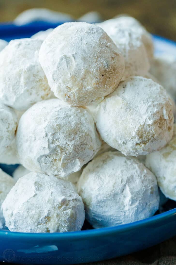 Russian Tea Cakes are easy to make and melt-in-your-mouth delicious. Add these little snowball cookies to your Christmas cookie platter. Russian tea cakes served on a blue plate