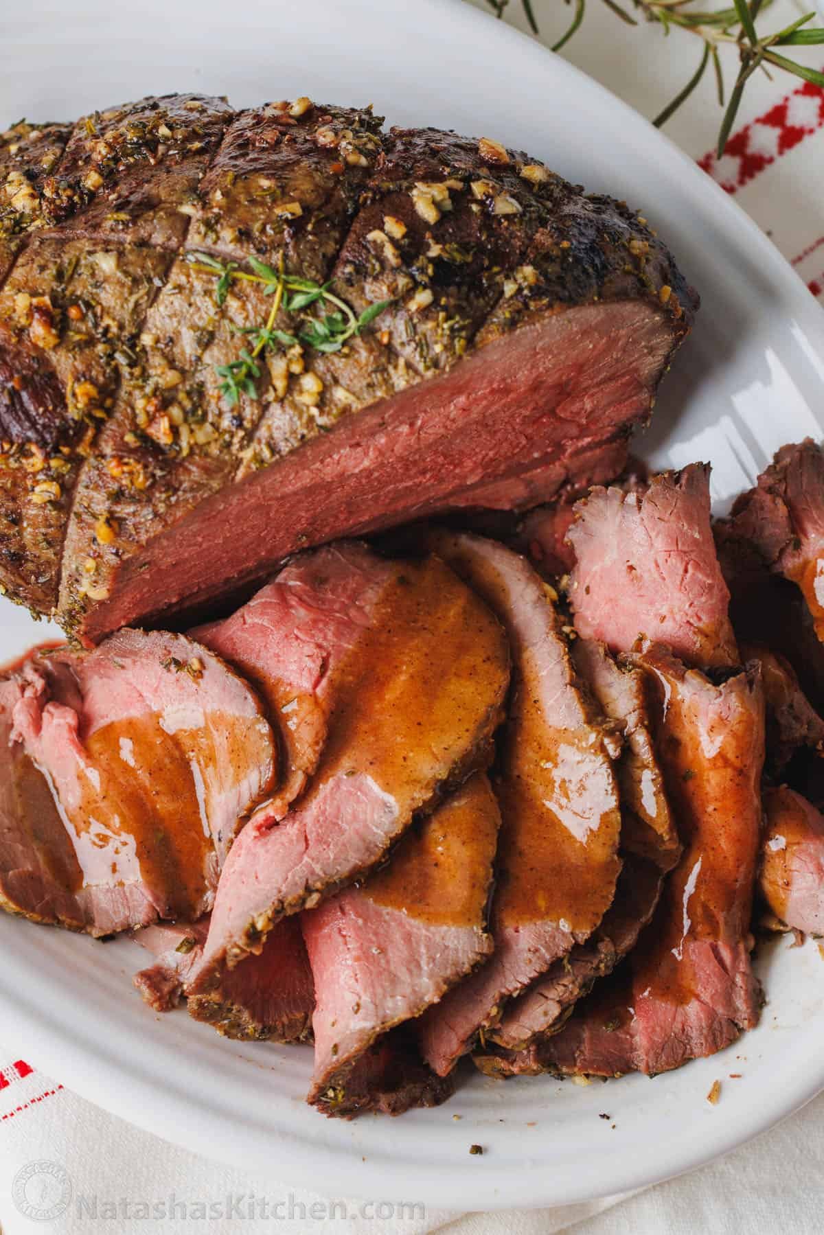 This simple, juicy Roast Beef with savory homemade pan gravy is just as impressive as any holiday roast. Every bite melts in your mouth. Perfect roast beef sliced thinly on a platter, drizzled with beef gravy.