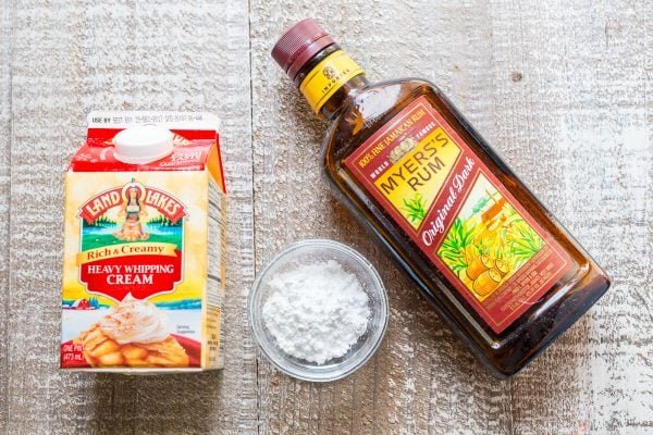 1 cup heavy whipping cream, a bowl of powdered sugar and rum on the table