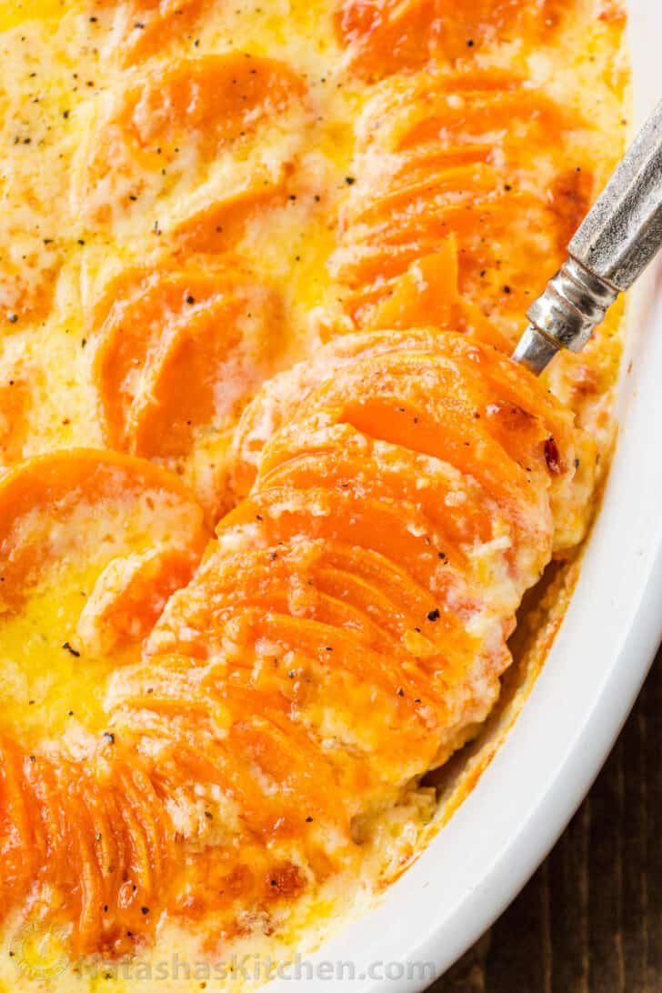 Stacked scalloped potatoes in a dish with a creamy sauce.