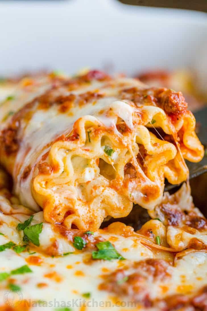 Make-ahead Lasagna roll up being scooped out of casserole dish