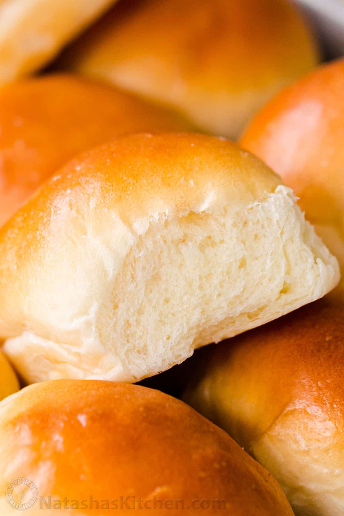 Irresistibly Soft Dinner Rolls are easy to make with just 6 ingredients. There's nothing like fluffy warm homemade dinner rolls. These are holiday worthy! #dinnerrolls #softdinnerrolls #homemadedinnerrolls #easydinnerrolls #howtomakedinnerrolls #natashaskitchen A pile of soft dinner rolls