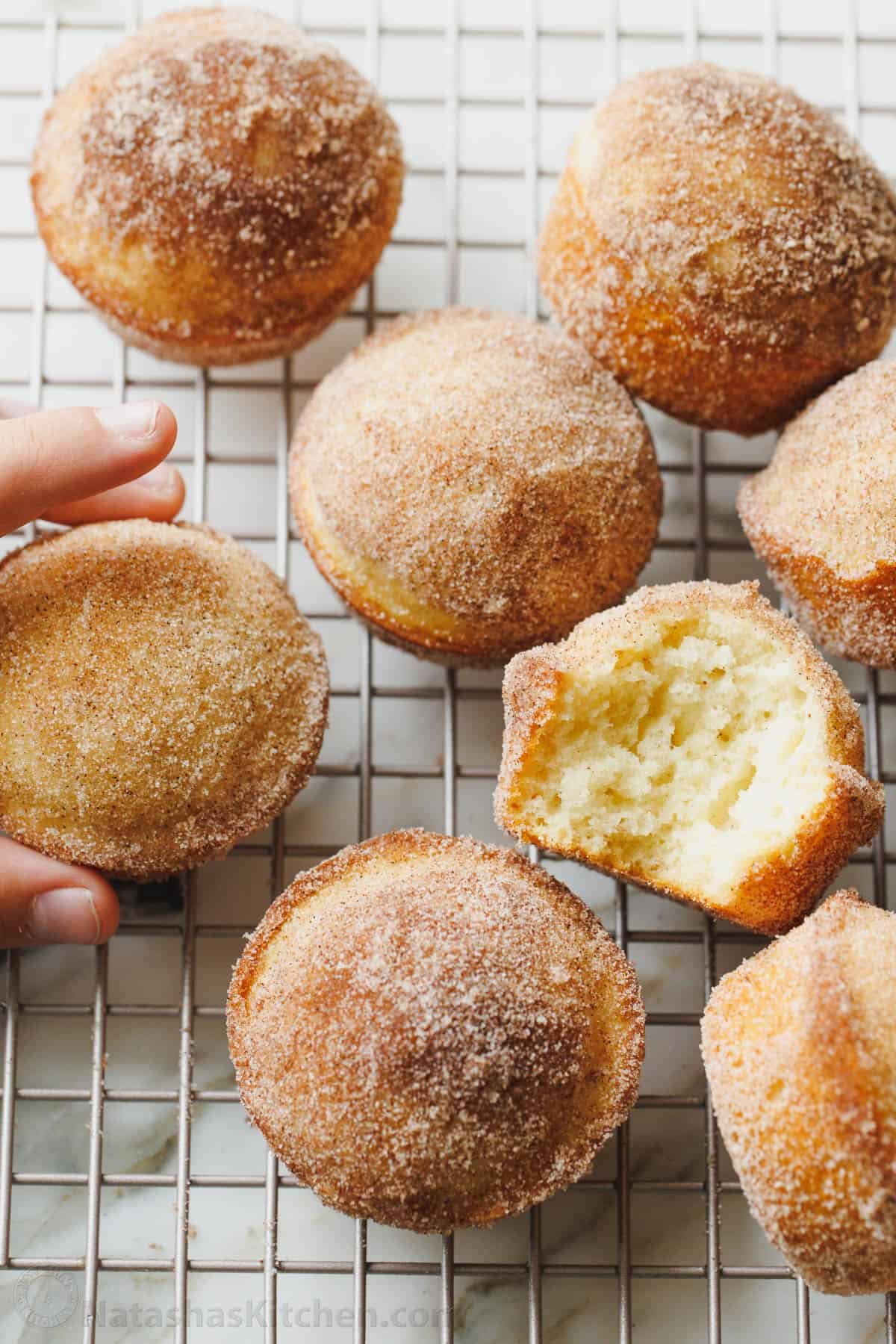 Fluffy cinnamon muffins filled with warm spice and dipped in cinnamon sugar for an irresistible, sugary crunch. Ready in 25 minutes! serving cinnamon muffin on a wire rack