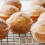 Cinnamon sugar coated cinnamon muffins on a wire rack.