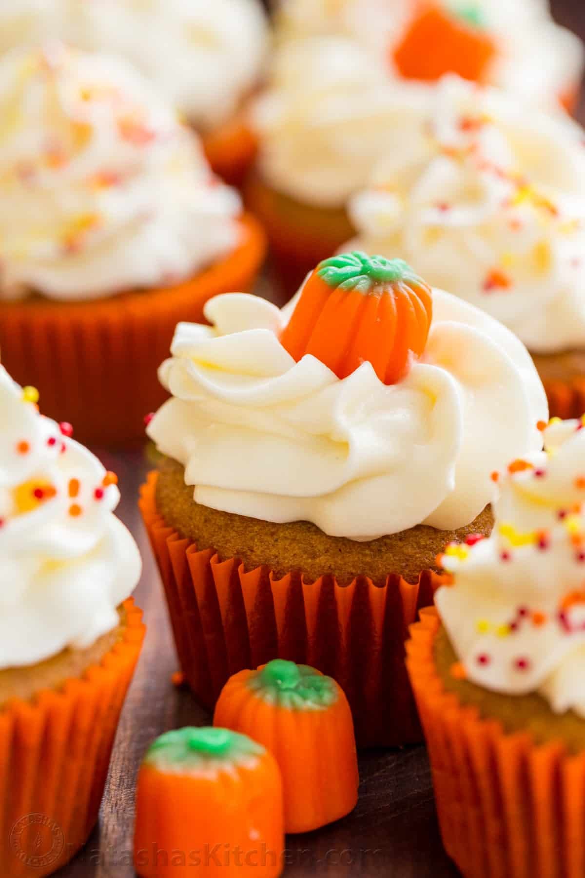 Taste the best pumpkin cupcake ever! It's a moist spiced pumpkin cupcake recipe with cream cheese frosting that bakes up quickly and easily. Fall-themed pumpkin cupcakes with sprinkles, cream cheese frosting and pumpkin candies