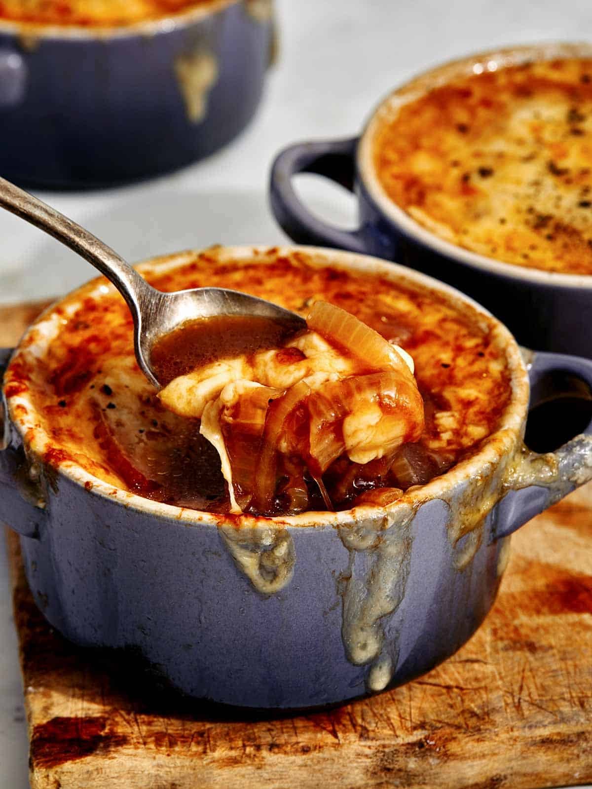 French onion soup recipe in a bowl with a spoon in it.