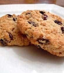 2 oatmeal raisin cookies on a white plate.
