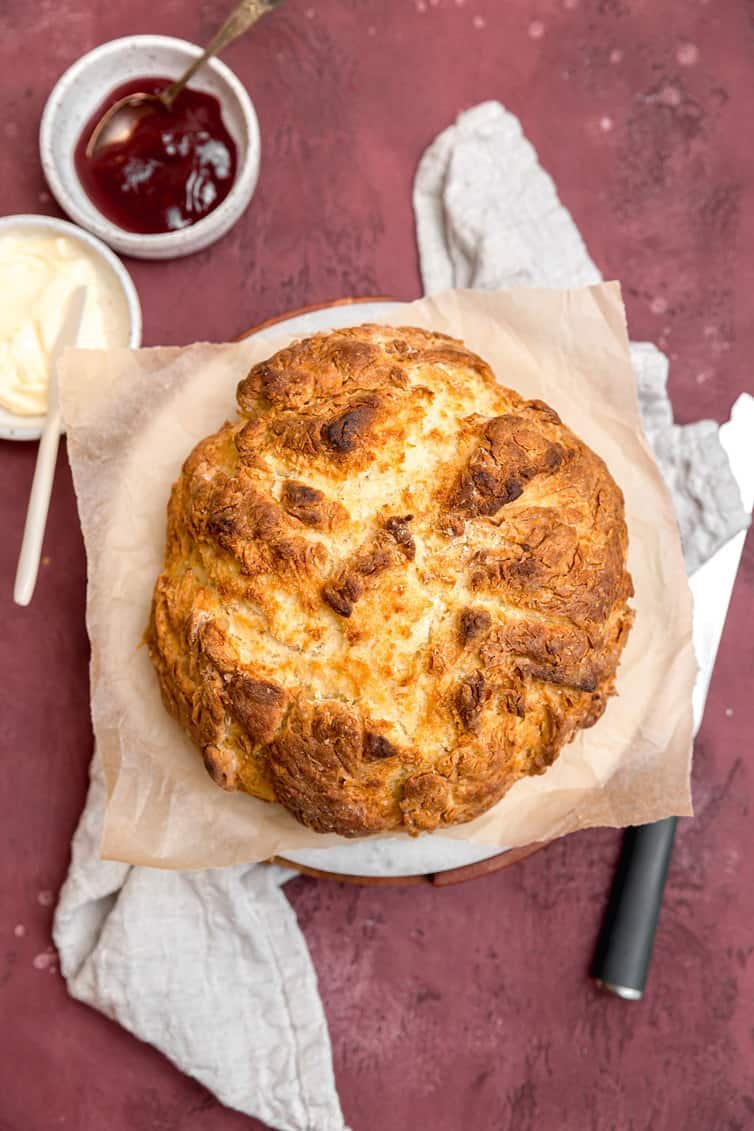Loaf of Irish soda bread with butter and jam.