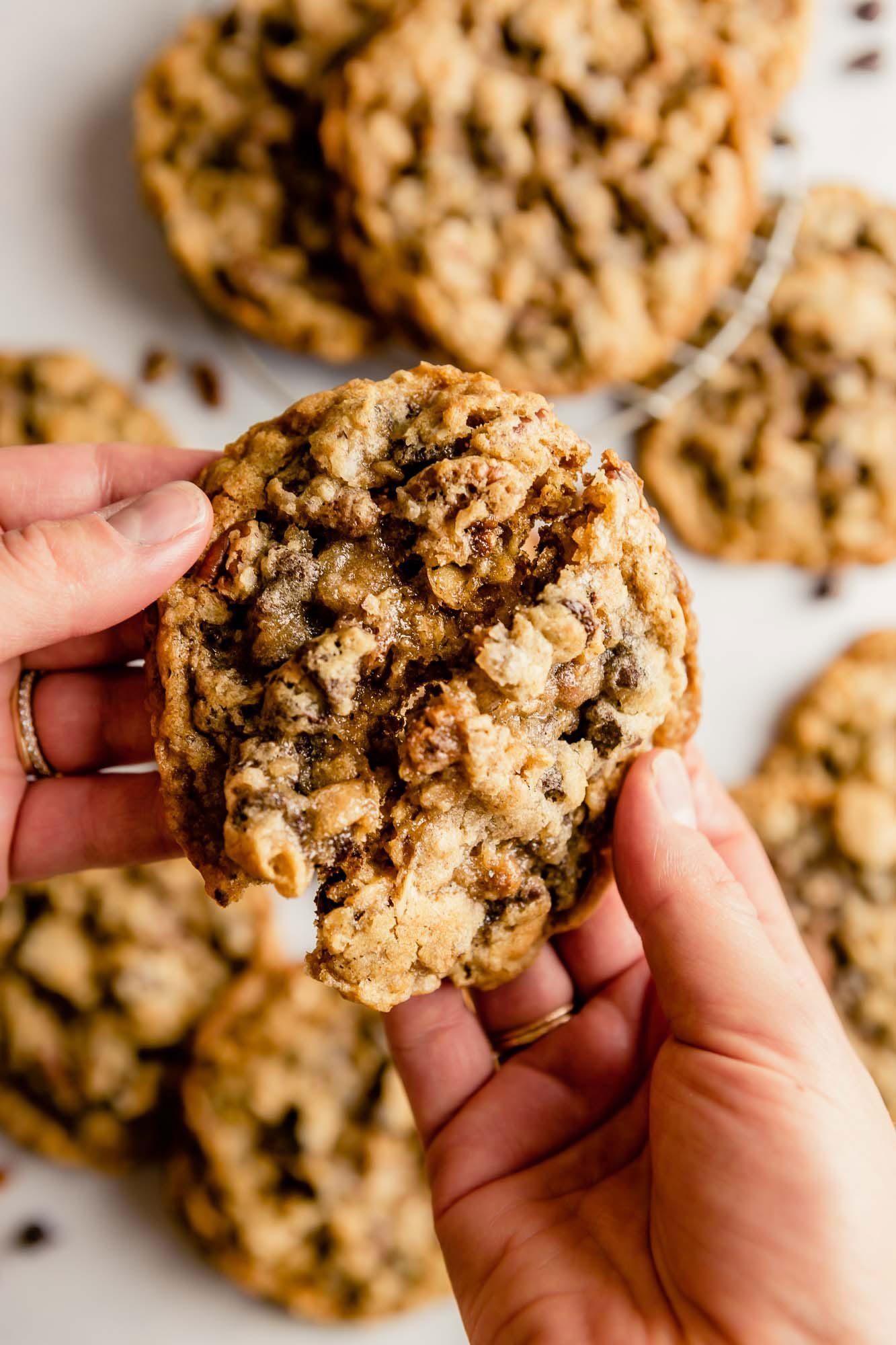 Two hands breaking a cookie in half.