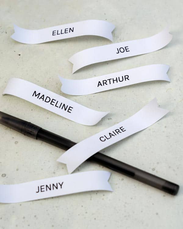 Curling the edges of name tags with a pen.