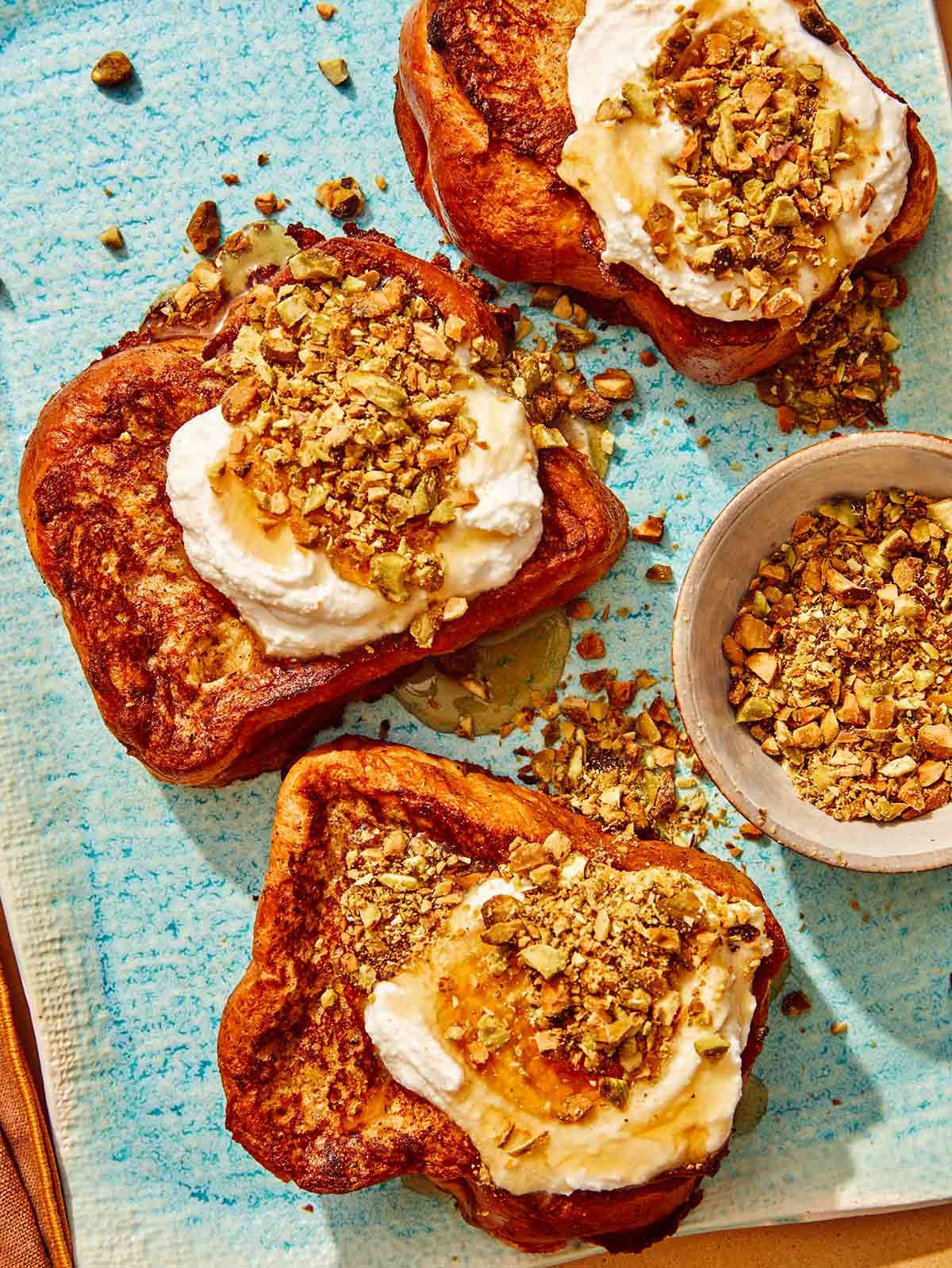 French toast on a platter topped with ricotta and nuts.