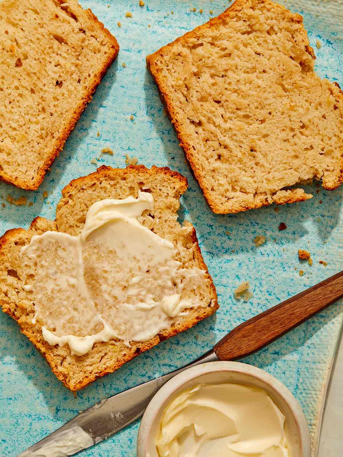 Beer bread on a plate with butter on the slices.