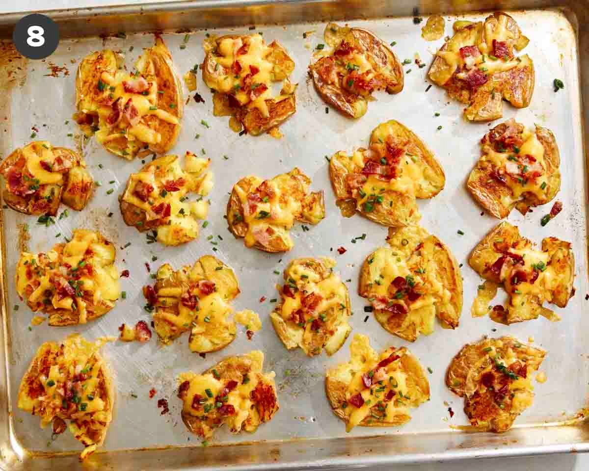 Smashed potatoes on a baking sheet topped with chives.
