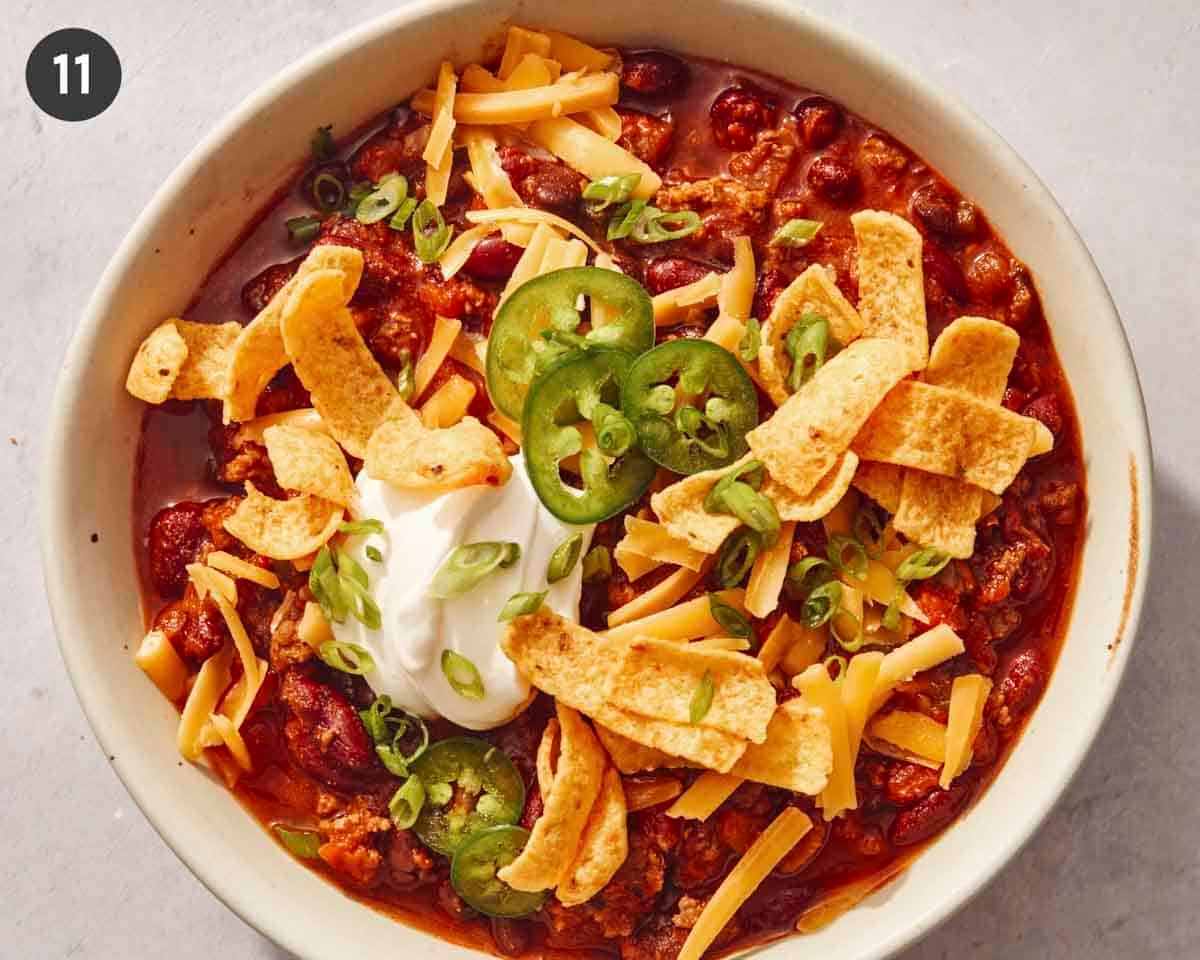 A bowl of chili with toppings.