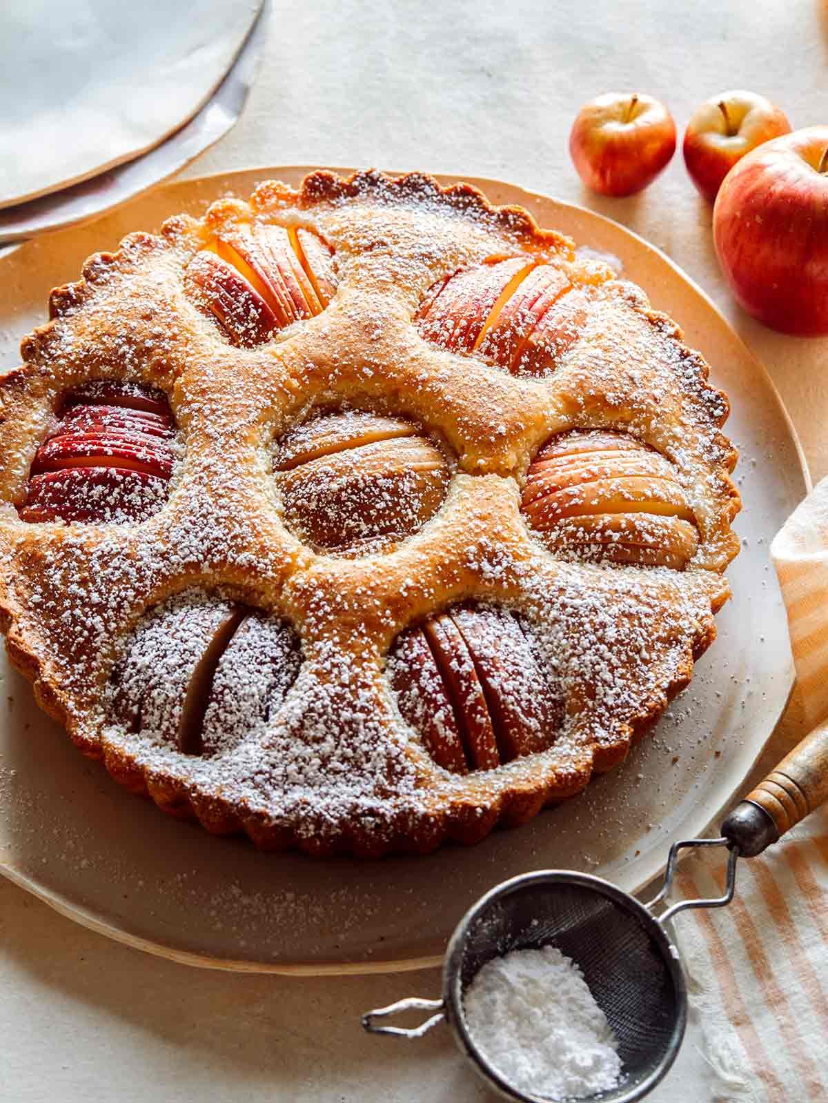 German apple cake on a platter with a stack of plates next to it. 