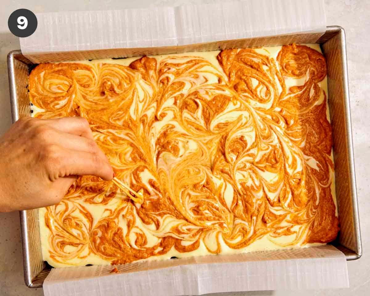 Marbled cheesecake bars being marbled.
