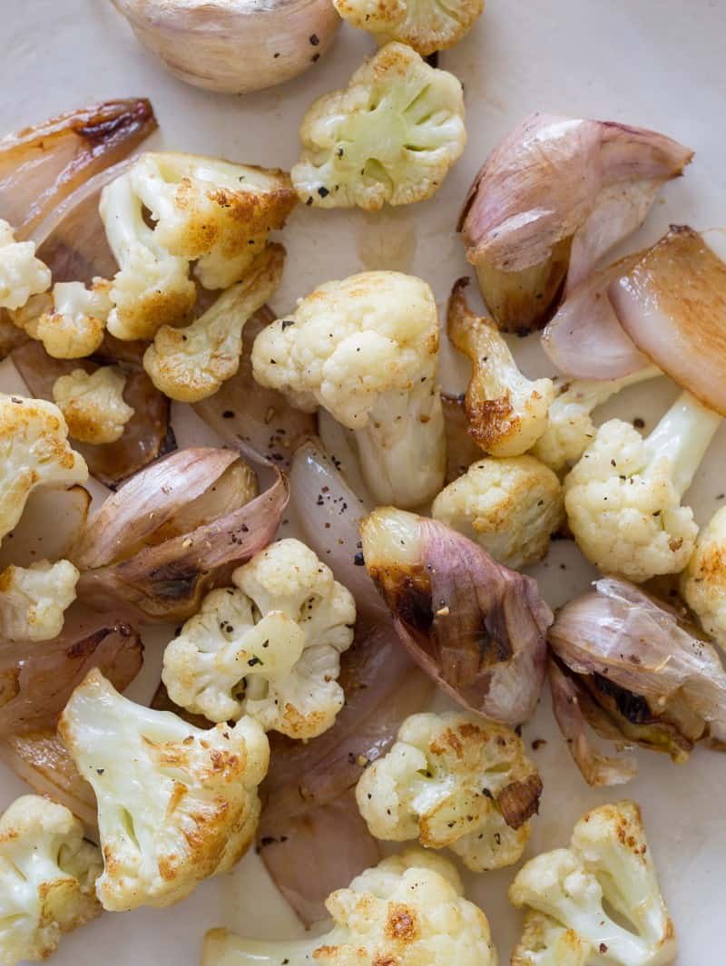 Vegan Cauliflower Cream Sauce ingredients A close up of roasted cauliflower, garlic, and shallots.