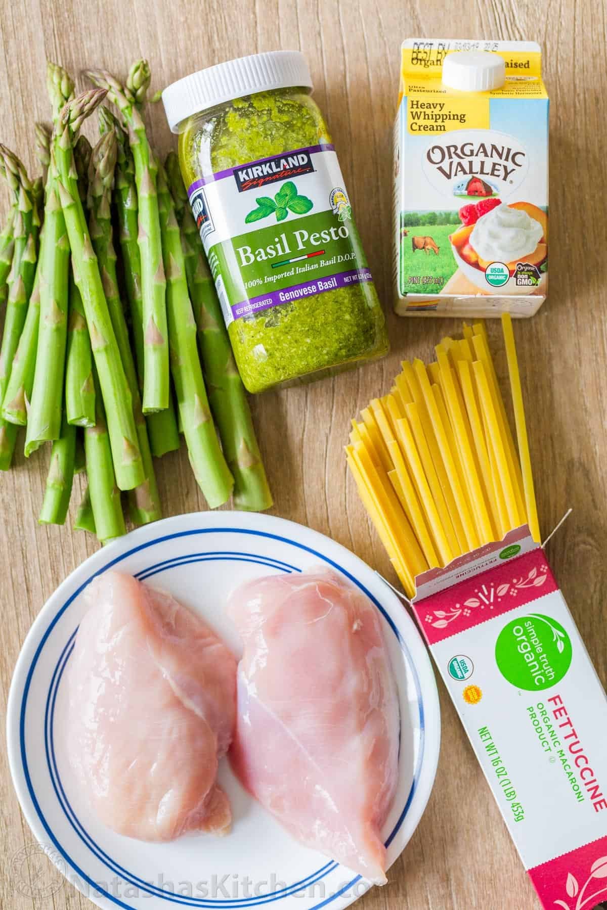 Chicken Pesto Pasta is an easy, 30-minute pasta dinner loaded with juicy chicken and asparagus. Try this crowd-pleasing pasta recipe! Chicken Pesto Pasta recipe ingredients with basil pesto, asparagus, heavy whipping cream, fettuccine noodles, and chicken breast