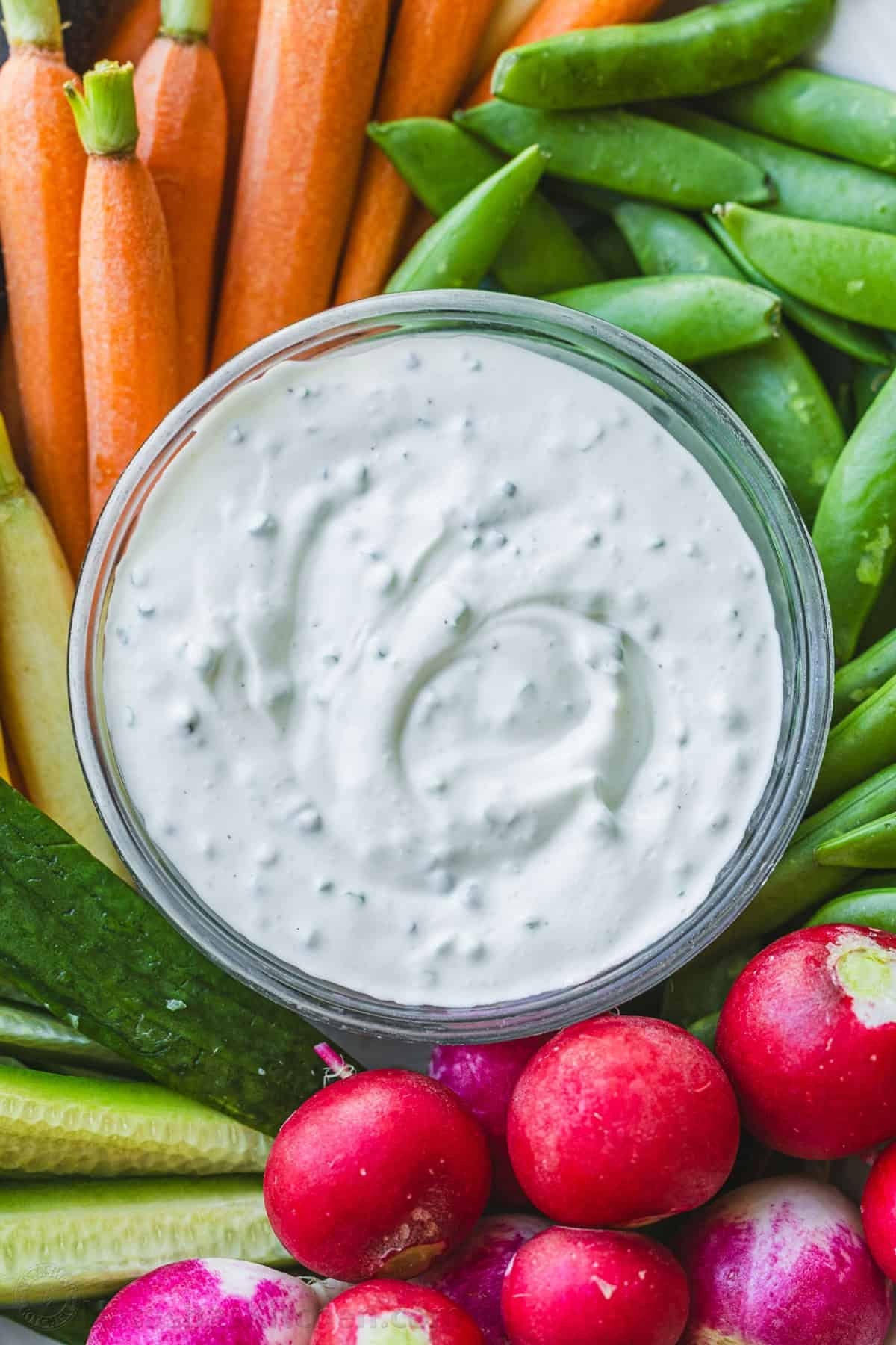 Easy Ranch Dip Recipe is ready in under 5 minutes with the best flavor and perfect thickness for dipping fresh vegetables and finger foods. Ranch dip in a clear bowl surrounded by raw vegetables like carrots, cucumbers, snap peas and radishes