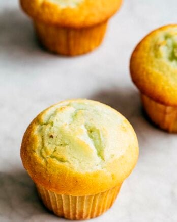 photo of three pistachio pudding muffins on a marble tabletop