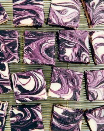 photo of sliced ube cheesecake bars on gold wire rack