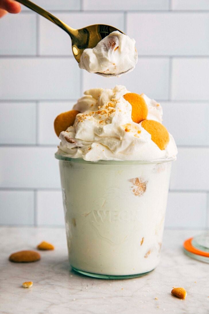 photo of small batch magnola bakery pudding in a pint jar with a scoop being lifted out