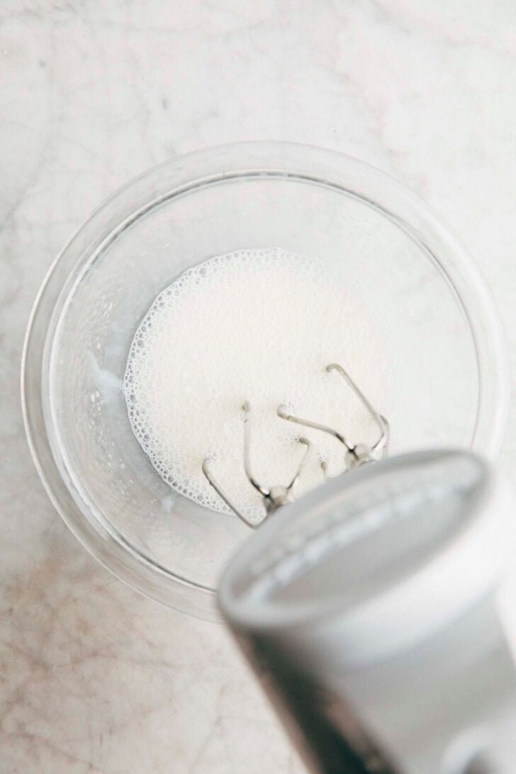 Photo of sweetened condensed milk and water being mixed for the recipe showing its bubbly texture