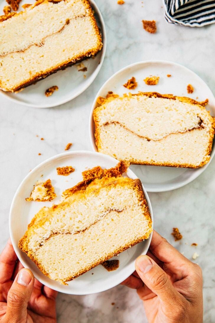 photo of snickerdoodle bread slices on small white plates with michelle of hummingbird high holding up one of the plates