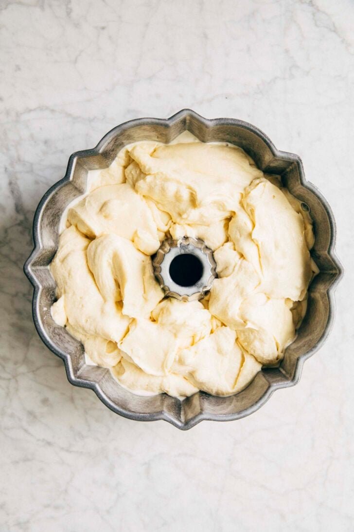 photo showing the coconut cake batter after being poured into the prepared bundt pan