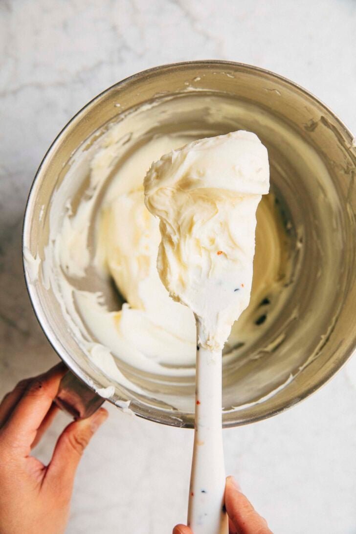 photo showing the texture of the cream cheese frosting for the coconut bundt cake
