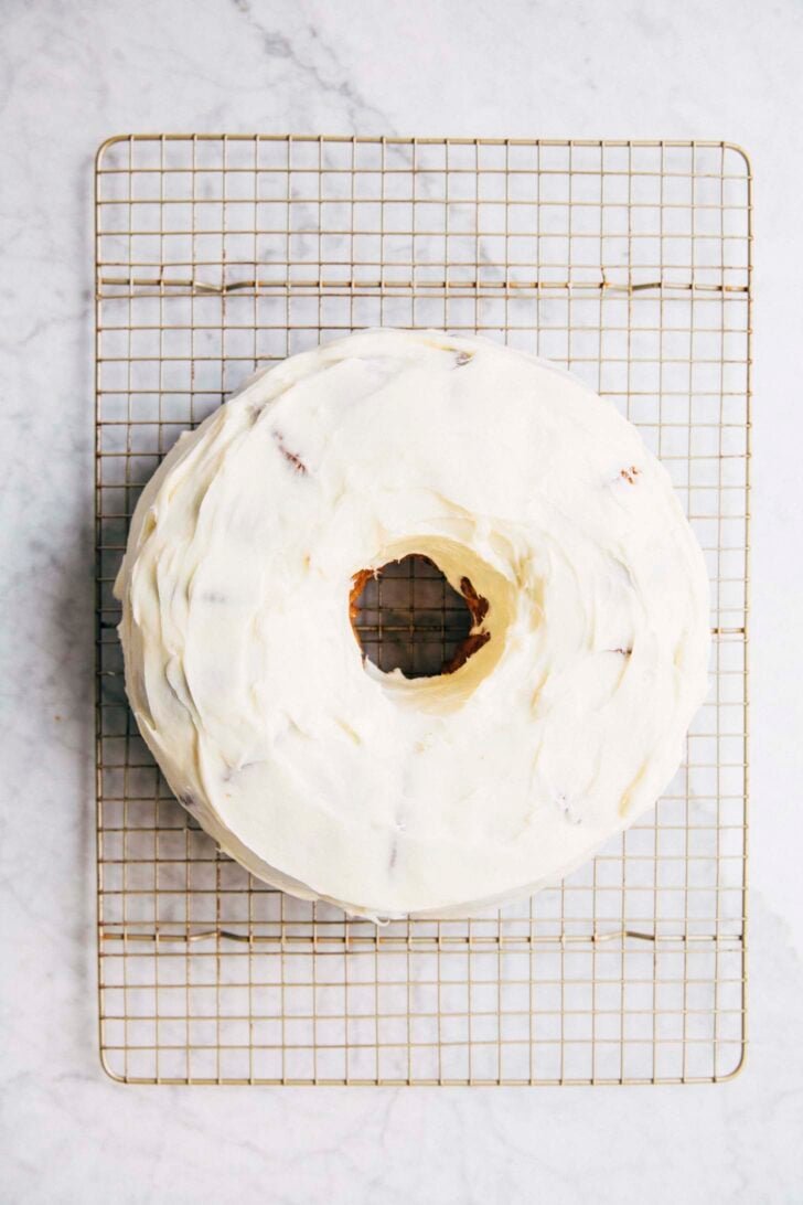 photo of the coconut bundt cake fully frosted before topped with toasted coconut