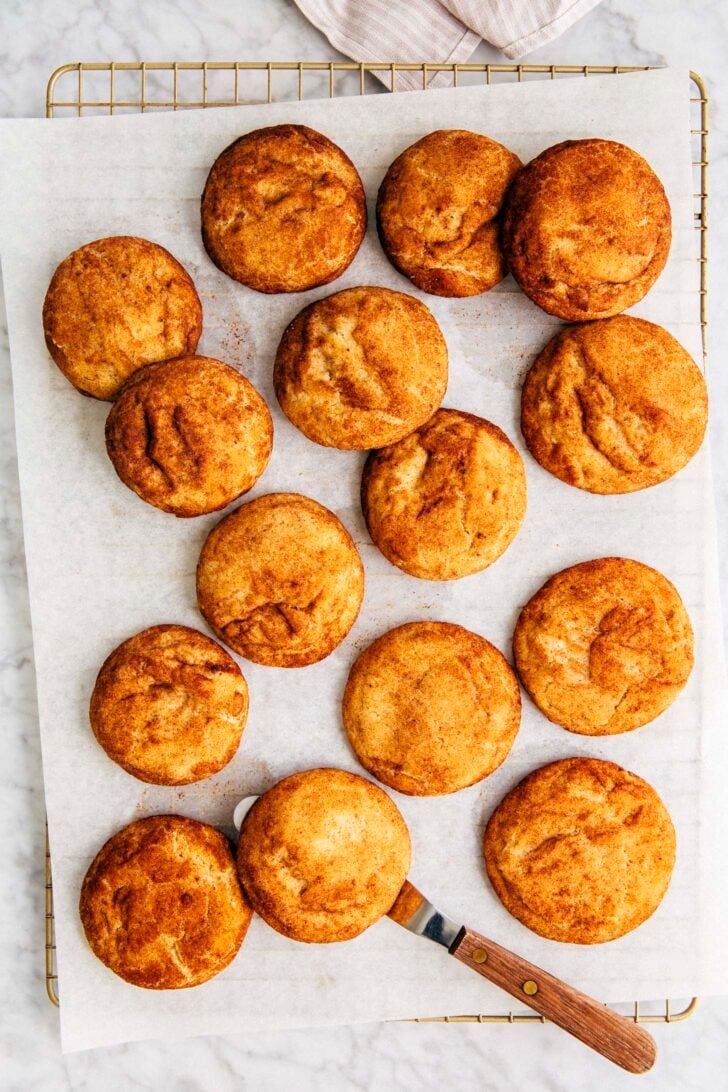 photo of brown butter snickerdoodles on white parchment paper on a wire rack