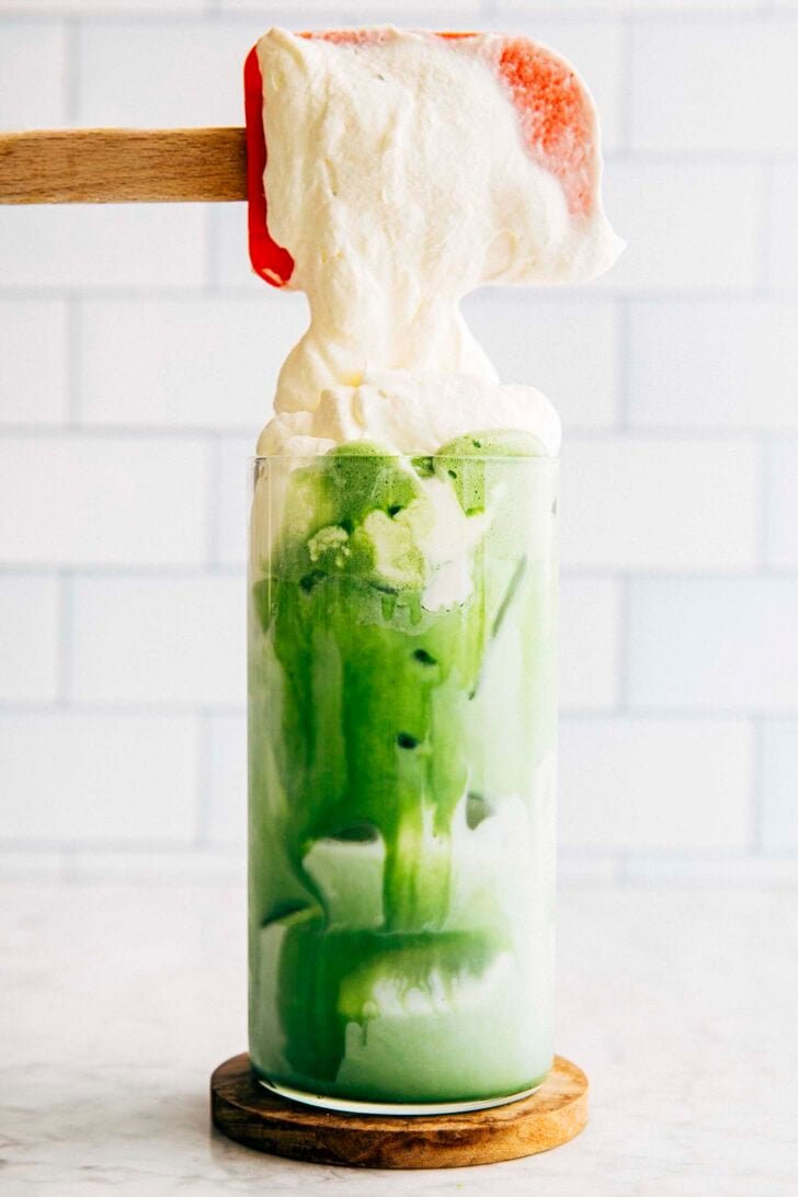 photo of michelle from hummingbird high scooping einspanner cream on top of the matcha latte