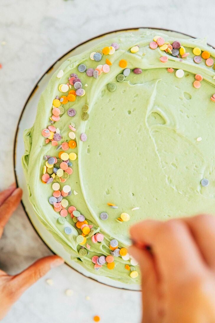photo of michelle from hummingbird high decorating the top of the pistachio pudding layer cake