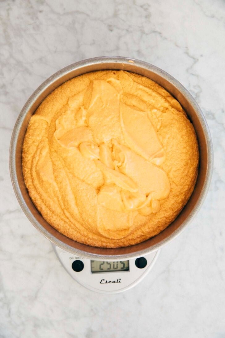photo of cake pan with Thai tea cake batter on a digital kitchen scale