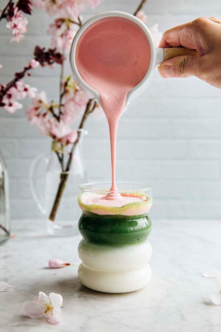 photo of cherry blossom cold foam being poured into a matcha latte
