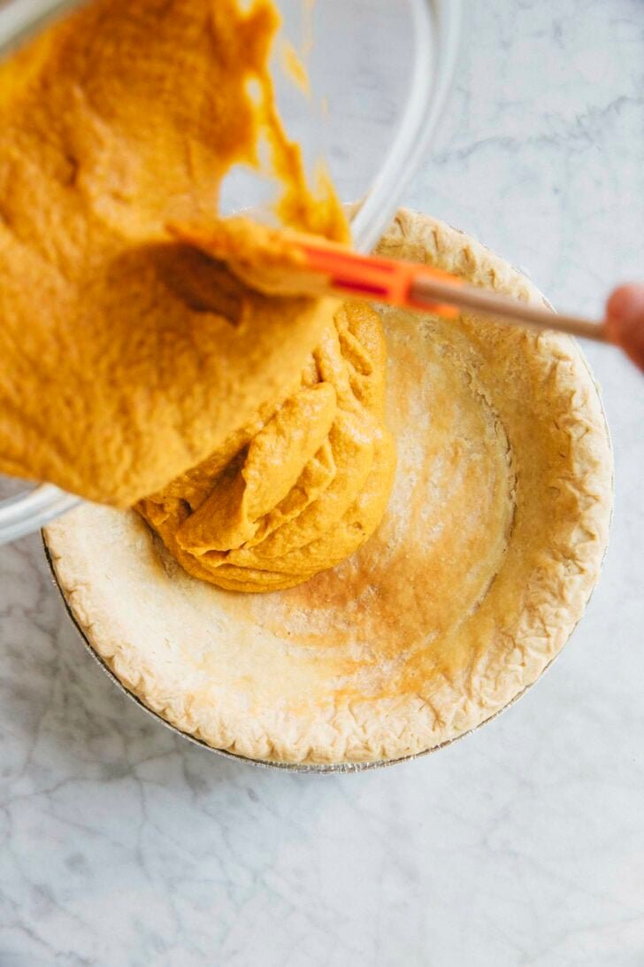 photo of michelle from hummingbird high filling the pre baked pie with cream cheese pumpkin pie filling
