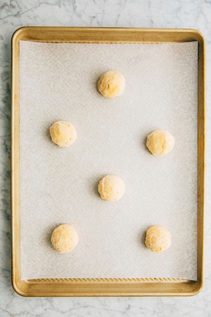 photo of the sugar cookie dough balls arranged on the pan before baking