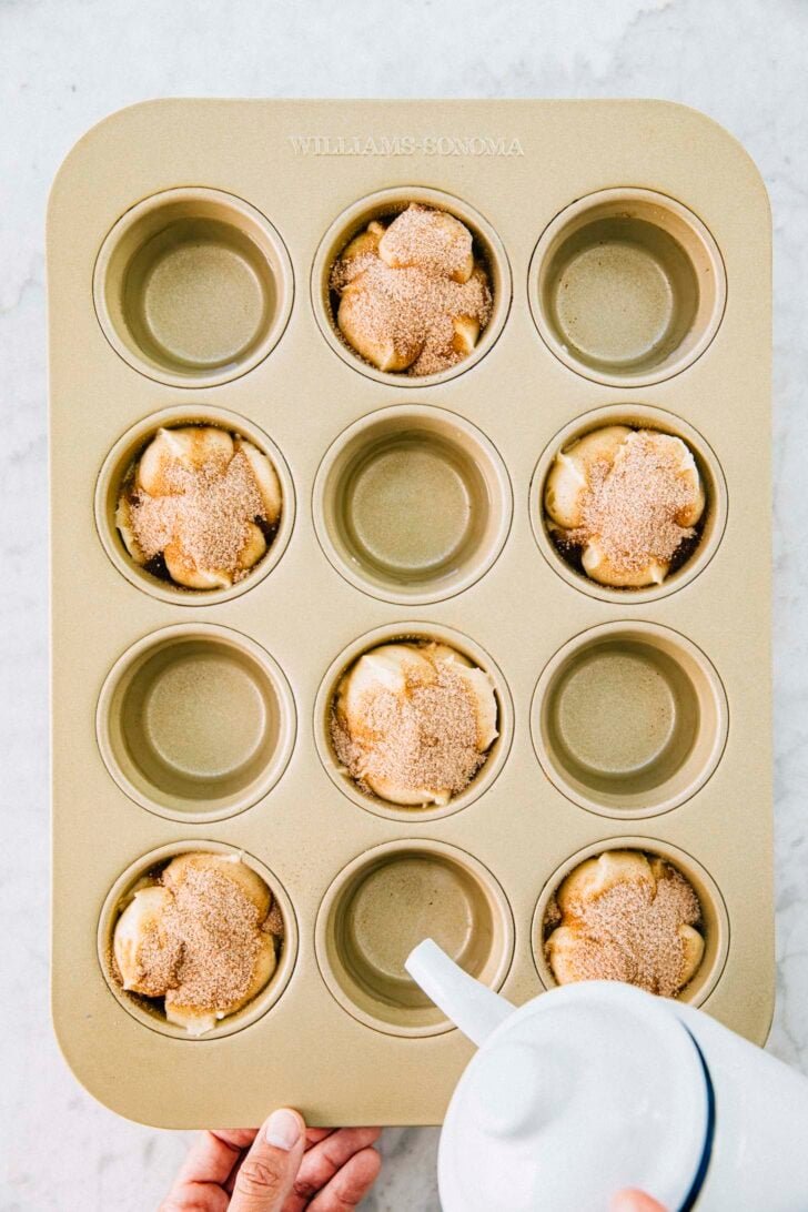 photo of michelle from hummingbird high pouring hot water into the empty cavities of the muffin pan