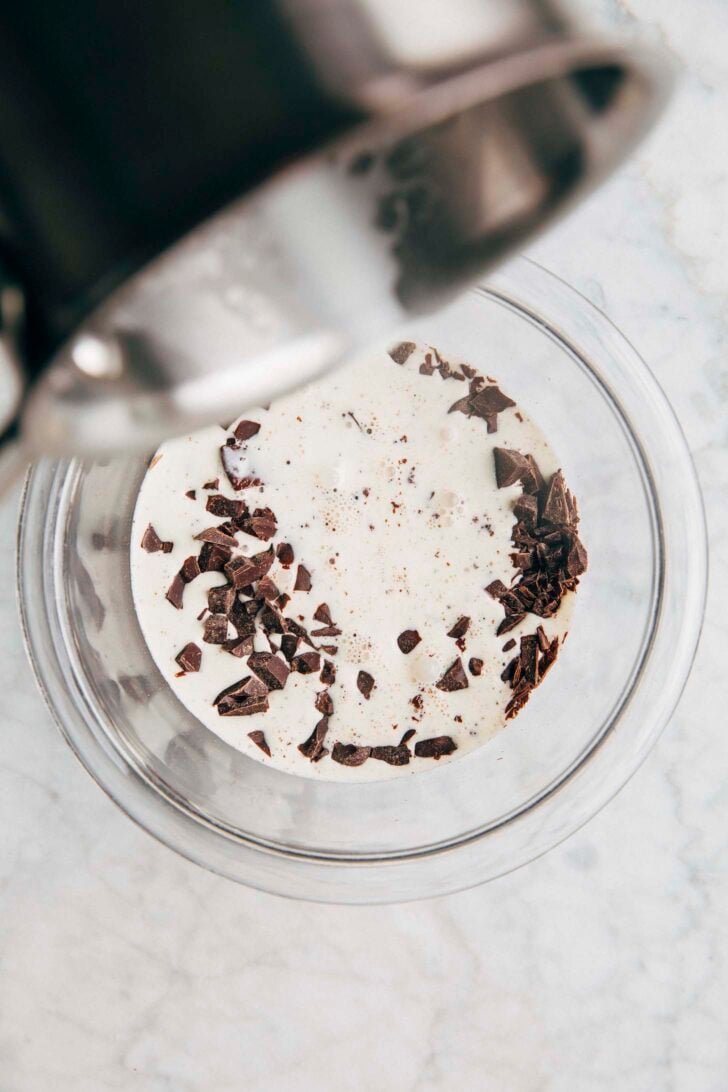 Photo of cream being poured over chopped chocolate to make ganache