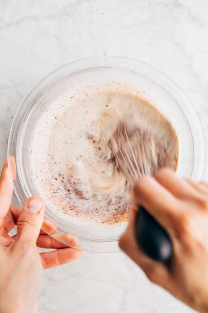 Photo of Michelle from Hummingbird High whisking hot cream into chopped chocolate to make ganache