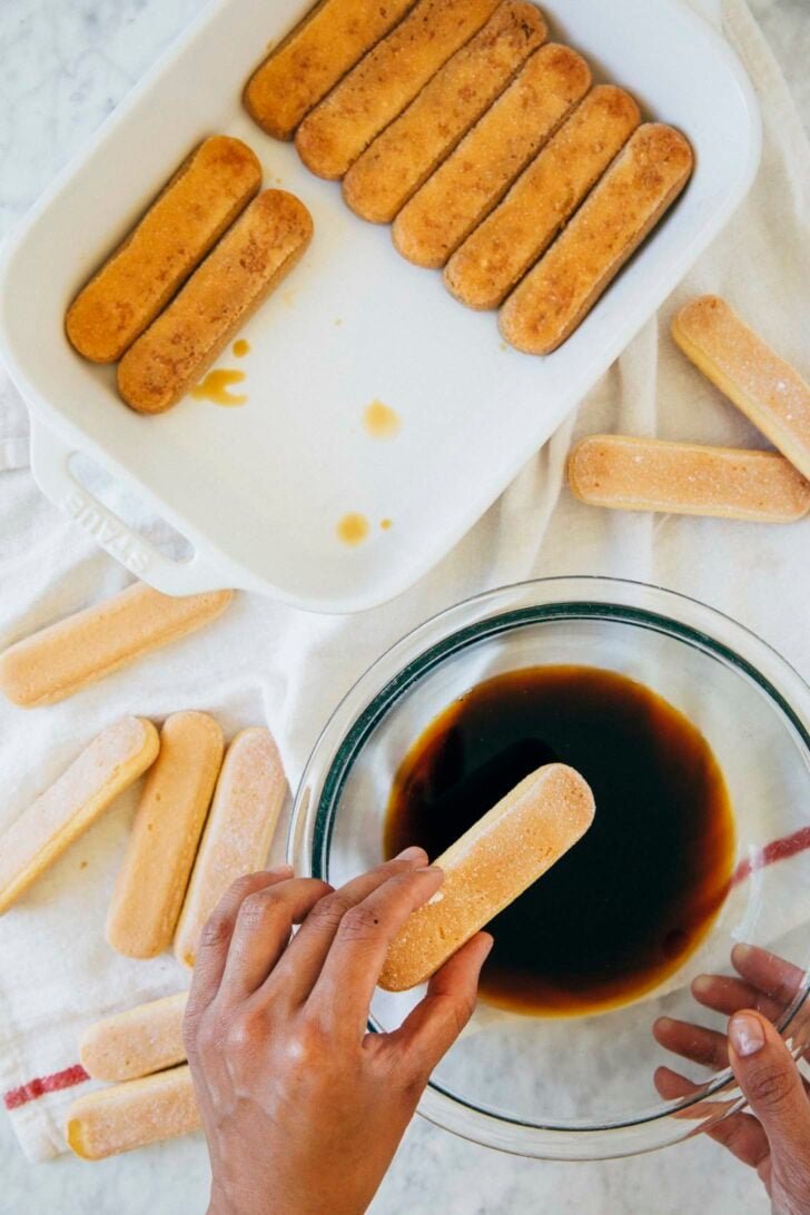 photo showing the process of soaking ladyfingers in espresso to make tiramisu