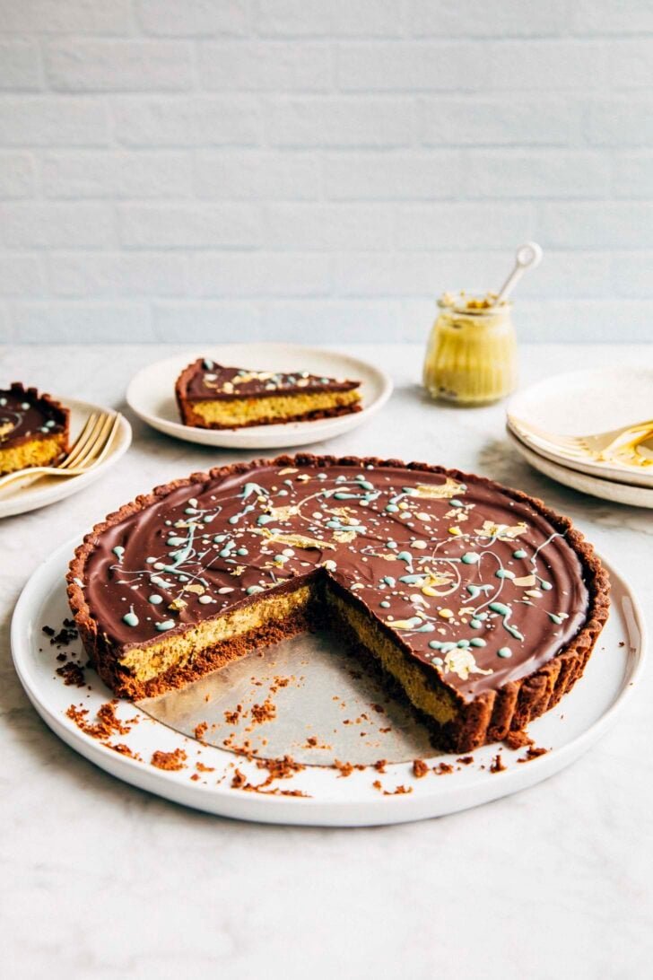 photo of the Dubai chocolate pistachio tart on a white plate showing off the crunchy pistachio kataifi crumb