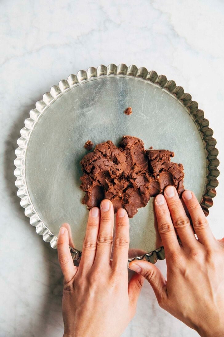 Photo of Michelle from Hummingbird High pressing the chocolate shortbread dough into a tart pan