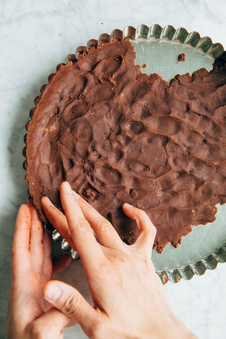 Photo of Michelle from Hummingbird High pressing the chocolate shortbread dough into a tart pan